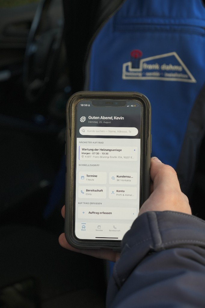 Monteur der Frank Dahms GmbH mit der Software auf dem Smartphone